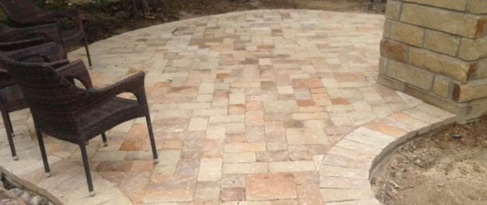 Light-colored paver patio with brown chairs in McKinney, TX.