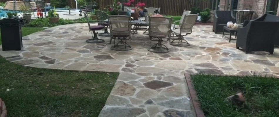 A stone paver patio in McKinney, TX, with a table and chairs.