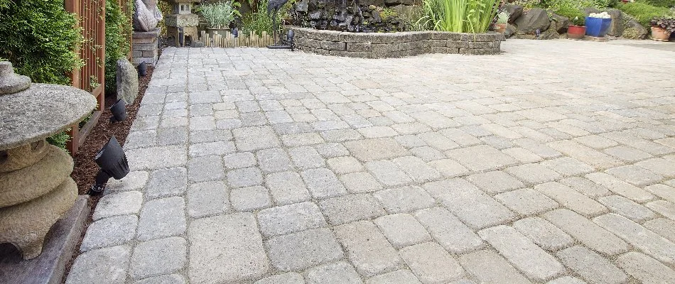 Concrete paver patio with landscaping in the background.