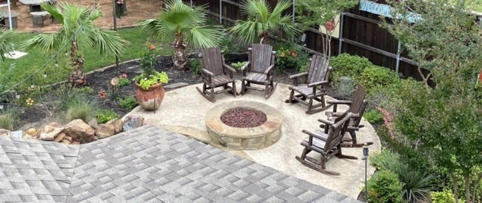 Patio in Prosper, TX, with fire pit, chairs, and landscape plants.