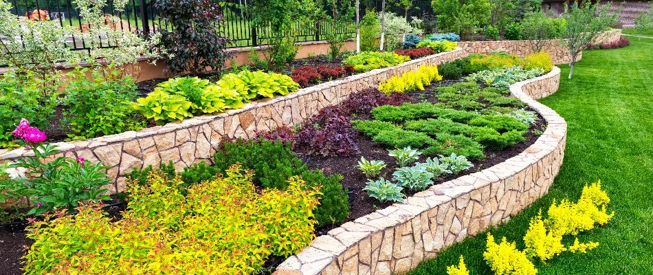 Retaining wall in McKinney, TX, as a planter bed with plantings and flowers.