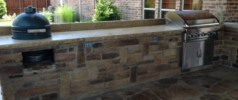 A customized outdoor kitchen in McKinney, TX, with a grill and a smoker.