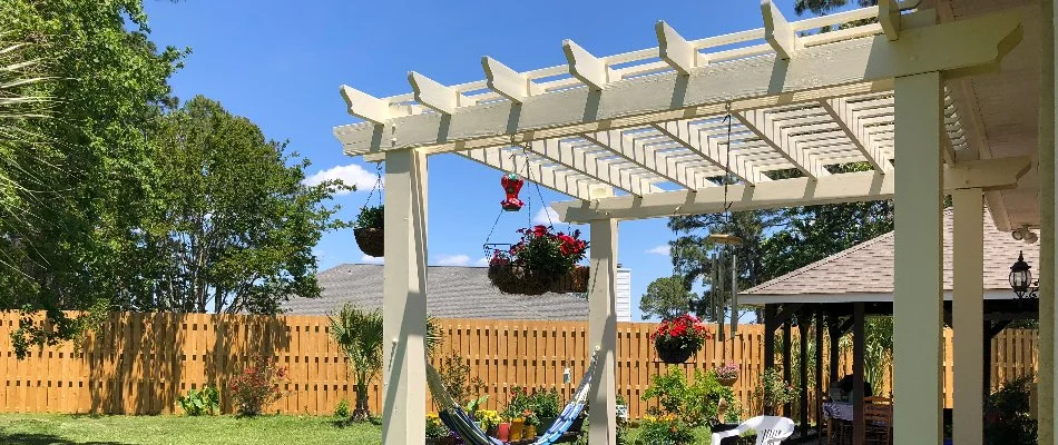 White pergola in McKinney, TX, with hanging plants.