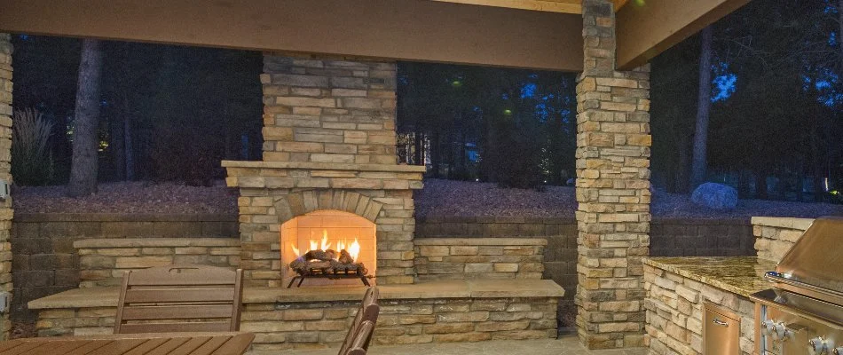 A wood-burning outdoor fireplace under a pavilion in McKinney, TX.